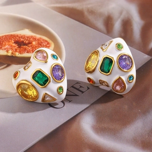 Détail de boucles d'oreilles plaquées or 18 carats avec émail blanc et gemmes colorées