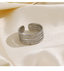 Detail of silver multi-layered textured open ring with hammered finish on satin fabric