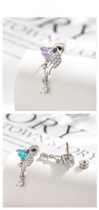 Detail view of heart-shaped zircon earrings with wing motif and drop pendant