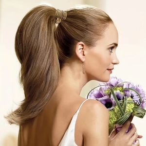 Detailed side view of a gold hollow metal ponytail clip on a model with blonde hair