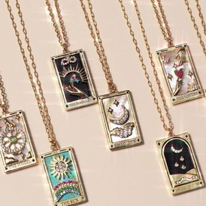 Makroansicht goldener Tarot-Halsketten mit Perlmutt- und Emaille-Inlay-Details