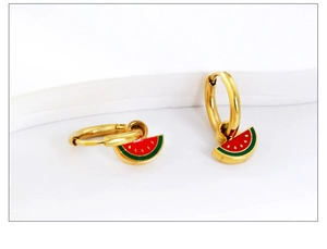 Detail of golden hoop earring with colorful enamel watermelon charm on white background