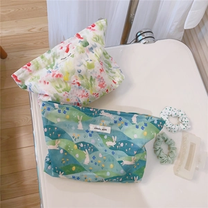 Detailed top view of floral and rabbit print cotton makeup bags with a simple wish tag