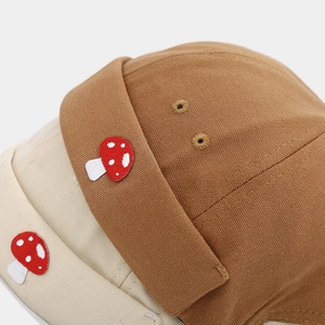 Macro detail of twill cotton docker hats featuring mushroom embroidery and metal eyelets
