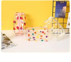 Detailed view of PVC transparent cosmetic bags with strawberry and daisy floral patterns