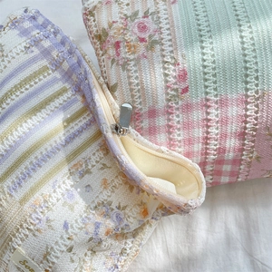 Close-up of quilted floral lace makeup bag with premium metal zipper and soft cotton texture