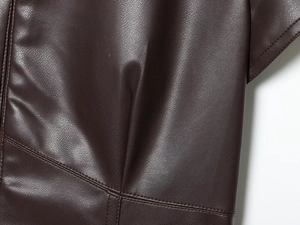 Detail view of dark brown faux leather fabric with premium double-stitch seam craftsmanship