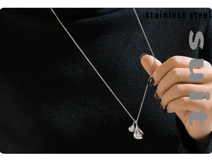 Close-up of a double teardrop silver pendant necklace on a black turtleneck sweater