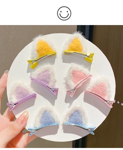 Close-up of four pairs of plush cat ear hair clips in yellow, purple, pink and blue