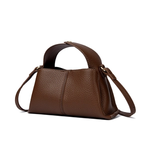 Detail of brown litchi pattern leather handbag showing handle and shoulder strap