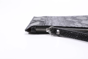 Close-up of black 3D python texture PU leather envelope clutch with silver metal zipper