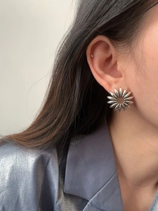 Close-up of a silver hollow petal stud earring featuring a vintage sunflower design