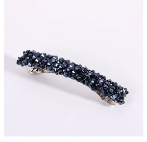 Vue détaillée d'une barrette à perles bleu foncé avec cristaux sur pince métallique