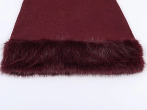 Detail of the knit wine red dress showing thick faux fur trim on the bottom hem
