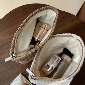 Close-up of woven cotton fabric cosmetic bags in beige and khaki with metal zippers