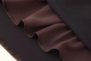 Detailed view of brown and black tiered chiffon fabric with elegant ruffled layers