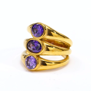 Detail of three-tier gold-plated ring featuring oval purple zircon stones in bezel settings