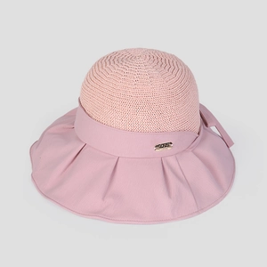 Detail of pink summer sun hat showing knit texture and decorative ribbon with metal logo