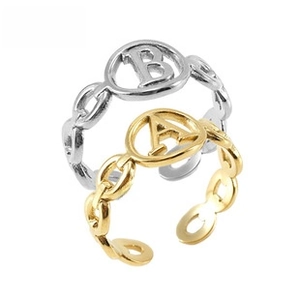 Detail of adjustable chain-link rings in gold and silver with shell letter pendants