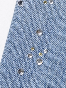 Vue macro détaillée de strass étincelants sur un tissu en denim bleu de qualité