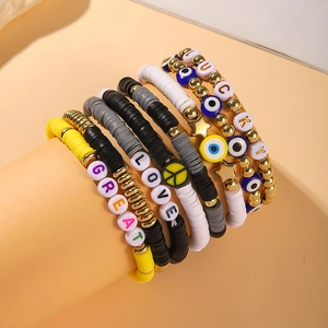 Bohemian stacked bracelets with clay beads, lucky letters and evil eye charms