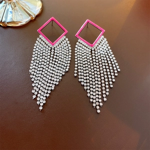 Close-up of long tassel earrings with rose red frames and silver rhinestone fringes