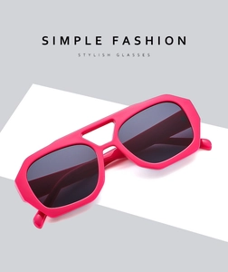 Close-up of stylish oversized pink frames and dark grey gradient lenses on a minimal background
