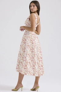 Detail of white floral sundress showing slim waist and flowing tiered hemline