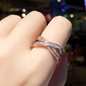 Close-up of elegant rose gold criss-cross ring with micro-pave crystals on a female hand
