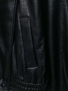 Close-up of the black leather jacket featuring fine texture and detailed pocket design