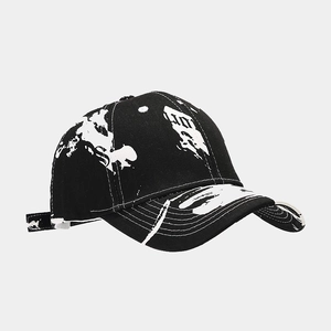 Detailed side view of the black baseball cap showing white graffiti splatter pattern