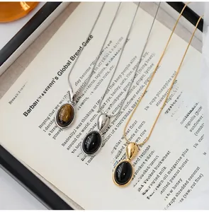 Detail of oval gemstone pendants on snake chains in silver and gold tones