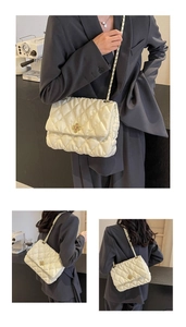 Detailed view of white quilted faux leather bag with gold chain and floral metal clasp