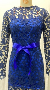 Detail of navy blue floral lace fabric and satin bow belt on a long-sleeved evening dress