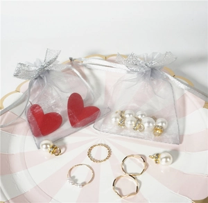 Gray sheer organza drawstring jewelry pouch with delicate bow and red heart earrings