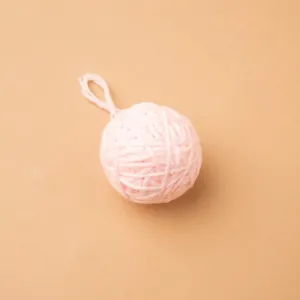Handmade pink yarn ball ornament with hanging loop for DIY Christmas decorations and props