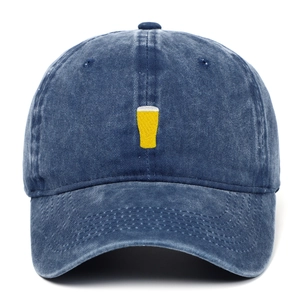 Détail de la broderie chope de bière jaune sur casquette en denim lavé avec effet vintage
