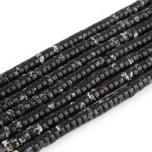Macro view of black marble patterned disc beads for DIY jewelry making and craft projects