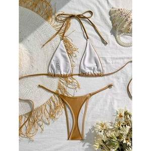 Lustrous metallic gold halter bikini set with string bottoms on a textured white background