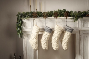 Close-up of four chunky knit Christmas stockings on a fireplace mantel decoration