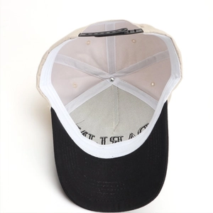 Two-tone beige and black embroidered baseball cap showing inner sweatband and adjustable strap
