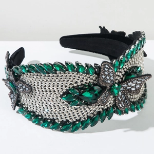 Detail view of a luxury wide headband with emerald crystals and sparkling rhinestones