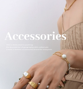 Detailed close-up of a gold-plated pearl bracelet and vintage rings on a model
