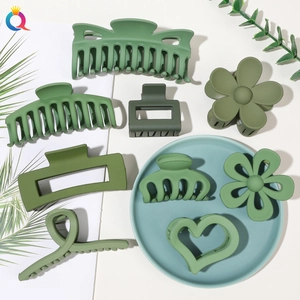 Detail view of assorted green matte hair claw clips in various geometric and flower shapes