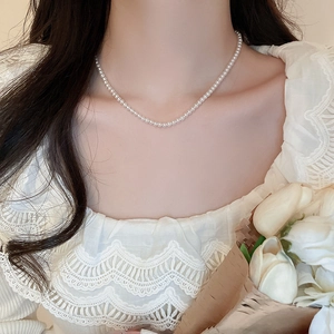 Elegant French style pearl choker necklace on a model with white lace and roses