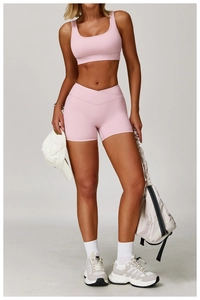 Detail view of pink high-waist crisscross shorts and yoga bra with premium matte finish