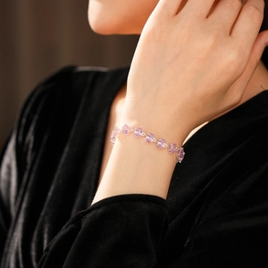 Detail of elegant silver bracelet with oval purple zircons worn on model's wrist