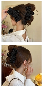 Détail d'une grande pince à cheveux en satin plissé noir avec strass sur un chignon