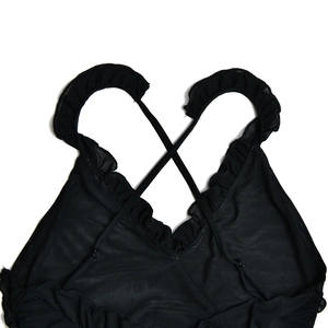 Detail of back view featuring crisscross straps and mesh fabric with ruffle trim