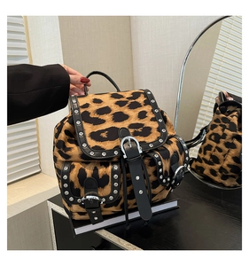 Close-up of leopard print backpack featuring silver rivet studs and buckle closure
